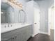 Well-lit bathroom featuring double sinks, decorative mirrors and light fixtures, plus unique textured walls at 11343 W Mccaslin Rose Ln, Surprise, AZ 85378