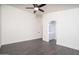 Bright bedroom with hardwood floors features a ceiling fan and attached bathroom with vanity at 11343 W Mccaslin Rose Ln, Surprise, AZ 85378