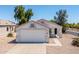 Inviting home featuring a clean exterior, a two-car garage, and low maintenance landscaping at 11343 W Mccaslin Rose Ln, Surprise, AZ 85378