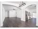 Bright living room featuring hardwood floors and open layout to the kitchen with stainless appliances at 11343 W Mccaslin Rose Ln, Surprise, AZ 85378