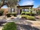 Charming stone home featuring a covered porch, meticulously landscaped yard, and lush green bushes at 12644 N 152Nd Ave, Surprise, AZ 85379