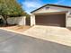 A front view of a home showing the two-car garage door, a walkway, and a tree at 12644 N 152Nd Ave, Surprise, AZ 85379