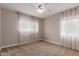 Cozy bedroom featuring neutral carpet, a ceiling fan, and sunlit windows with sheer curtains at 1316 E Vermont Ave, Phoenix, AZ 85014