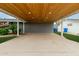 Spacious carport featuring a wood plank ceiling, concrete flooring, and a well-maintained lawn at 1316 E Vermont Ave, Phoenix, AZ 85014