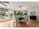 Well-lit dining area with wood floors, stylish seating, and backyard views through large windows at 1316 E Vermont Ave, Phoenix, AZ 85014