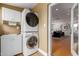 Convenient laundry room with stacked washer and dryer and nearby storage cabinets at 1316 E Vermont Ave, Phoenix, AZ 85014