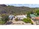 Expansive estate with a main house, garage with solar panels, and tennis court, nestled against a scenic hillside at 14814 N Coral Gables Dr, Phoenix, AZ 85023