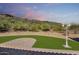 Landscaped backyard with synthetic grass, patio, and desert view at 14814 N Coral Gables Dr, Phoenix, AZ 85023