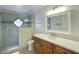 Bright bathroom featuring a glass enclosed shower with decorative window and vanity with white countertop at 14814 N Coral Gables Dr, Phoenix, AZ 85023