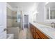 Spacious bathroom showcasing dual vanities, a glass-enclosed shower, and neutral toned tile at 14814 N Coral Gables Dr, Phoenix, AZ 85023
