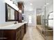 Elegant bathroom boasting a walk-in shower, soaking tub, and vanity with dark wood cabinets at 14814 N Coral Gables Dr, Phoenix, AZ 85023