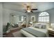 Serene bedroom featuring a mirrored closet, arched window, and calming color palette at 14814 N Coral Gables Dr, Phoenix, AZ 85023