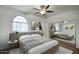 Stylish bedroom featuring a ceiling fan, large window, and mirrored closet doors at 14814 N Coral Gables Dr, Phoenix, AZ 85023