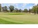 A wide shot of the golf course with rolling green hills, lined with mature trees and clear blue skies above at 14814 N Coral Gables Dr, Phoenix, AZ 85023