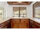 Stylish wet bar with granite countertops, dark wood cabinetry, and a view to the outside at 14814 N Coral Gables Dr, Phoenix, AZ 85023