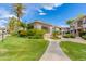 Exterior view of home with lush green landscaping and mature palm trees at 15221 N Clubgate Dr # 2132, Scottsdale, AZ 85254