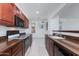 Kitchen featuring brown countertops, dark appliances, and wooden cabinets, with an open view of adjacent rooms at 15221 N Clubgate Dr # 2132, Scottsdale, AZ 85254