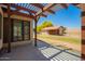 Back patio featuring a pergola with view of a barn, a yellow-flowered tree, and a fenced-in field at 1637 S Los Alamos Cir, Mesa, AZ 85204