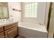 Bright bathroom features a soaking tub, glass block window, and spacious vanity at 1637 S Los Alamos Cir, Mesa, AZ 85204