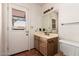 Well-lit bathroom with a door to the outside, a wooden vanity, and a toilet at 1637 S Los Alamos Cir, Mesa, AZ 85204