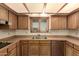 Close up of kitchen with wood cabinets, stainless sink and dishwasher at 1637 S Los Alamos Cir, Mesa, AZ 85204