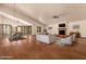 Bright living room features hardwood floors, vaulted ceilings, and a cozy brick fireplace with a TV above at 1637 S Los Alamos Cir, Mesa, AZ 85204