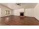 Bright living room features hardwood floors, large brick fireplace, and ceiling fan at 1637 S Los Alamos Cir, Mesa, AZ 85204