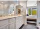 Bright bathroom featuring a dual sink vanity with marble countertops and a view into the main bedroom at 16600 N Thompson Peak Pkwy # 2050, Scottsdale, AZ 85260
