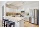 Well-lit kitchen featuring white cabinets, stainless steel appliances, and a spacious island with seating for casual dining at 16600 N Thompson Peak Pkwy # 2050, Scottsdale, AZ 85260