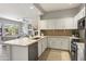Bright kitchen with stainless steel appliances, white cabinetry, and open view to the living room at 16600 N Thompson Peak Pkwy # 2050, Scottsdale, AZ 85260