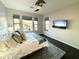 Bright bedroom featuring a ceiling fan, large windows, and a large-screen television at 16600 N Thompson Peak Pkwy # 2050, Scottsdale, AZ 85260