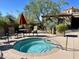 Relaxing outdoor jacuzzi with umbrella, chairs, and lush greenery for ultimate leisure at 16600 N Thompson Peak Pkwy # 2050, Scottsdale, AZ 85260