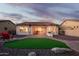 Beautiful backyard with artificial turf, covered patio, and built-in barbecue, great for entertaining at 18033 W Tecoma Rd, Goodyear, AZ 85338
