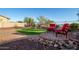 Inviting backyard showcases a cozy seating area with two red chairs, enhancing the outdoor living experience at 18033 W Tecoma Rd, Goodyear, AZ 85338
