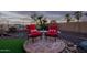 Backyard features comfortable red seating with a patio, desert landscaping, and a serene outdoor retreat at 18033 W Tecoma Rd, Goodyear, AZ 85338
