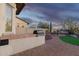 The covered outdoor kitchen features a barbecue grill and the patio has views of the decorative desert landscape at 18033 W Tecoma Rd, Goodyear, AZ 85338