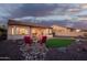 Relaxing backyard oasis with a patio seating area, artificial turf, and serene desert landscaping at 18033 W Tecoma Rd, Goodyear, AZ 85338