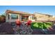 A backyard seating area has a cozy arrangement, with artificial turf, desert landscaping and paved patio at 18033 W Tecoma Rd, Goodyear, AZ 85338