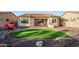 Backyard with artificial turf, desert landscaping and stone pavers featuring an outdoor seating area at 18033 W Tecoma Rd, Goodyear, AZ 85338