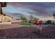 Relaxing backyard with artificial turf, a paver patio, and comfortable seating next to desert landscaping at 18033 W Tecoma Rd, Goodyear, AZ 85338