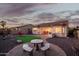Inviting backyard with a stone patio, artificial grass, and lovely desert landscaping at 18033 W Tecoma Rd, Goodyear, AZ 85338