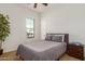 A sunlit bedroom with a window, a bed, and a wooden nightstand at 18033 W Tecoma Rd, Goodyear, AZ 85338