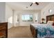 Spacious bedroom featuring large windows, a ceiling fan, and carpeted floors, offering a bright and comfortable living space at 18033 W Tecoma Rd, Goodyear, AZ 85338