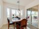 Bright dining room featuring a wooden table set next to sliding glass doors and large bay window at 18033 W Tecoma Rd, Goodyear, AZ 85338