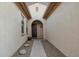 Inviting home entryway with an arched doorway, a stone pathway, and desert landscaping at 18033 W Tecoma Rd, Goodyear, AZ 85338