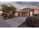 Attractive home exterior at dusk featuring a well-maintained yard and a paved driveway at 18033 W Tecoma Rd, Goodyear, AZ 85338