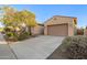 Single story beige house featuring a spacious two car garage and desert landscaping at 18033 W Tecoma Rd, Goodyear, AZ 85338