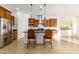 Modern kitchen features stainless steel appliances, granite countertops, and stylish pendant lighting over the island at 18033 W Tecoma Rd, Goodyear, AZ 85338