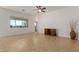 Bright living room featuring tile floors, ceiling fan, storage cabinet, and large window views at 18033 W Tecoma Rd, Goodyear, AZ 85338