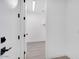 Hallway leading to a closet, showcasing white walls and doors with black hardware at 18123 W Hiddenview Dr, Goodyear, AZ 85338